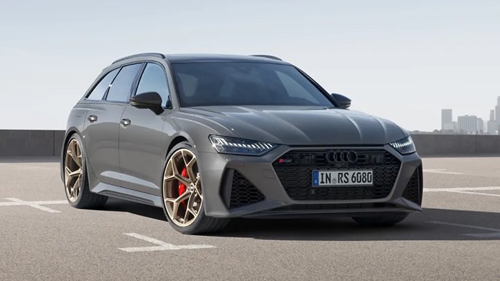 Grey Audi RS6 Avant parked on the asphalt with large skyscrapers in the background