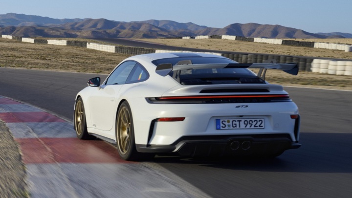 Porsche 911 GT3 driving on race track rear left