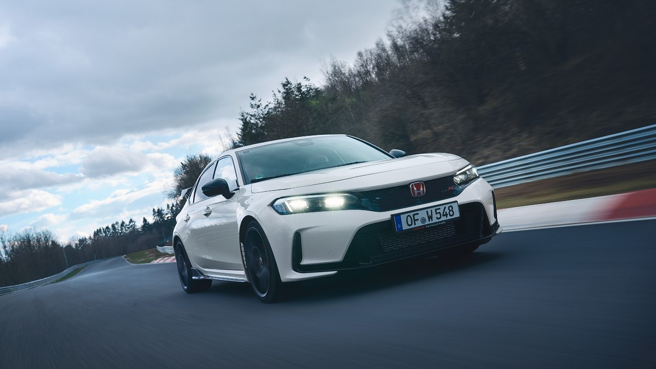 White Honda Civic Type R driving on race track front left