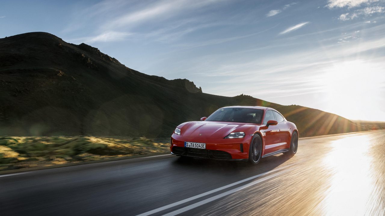Red Porsche Taycan driving on mountain road