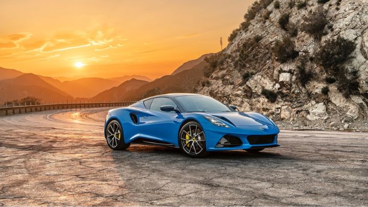 Blue Lotus Emira parked in the mountains with a beautiful sunset in the background