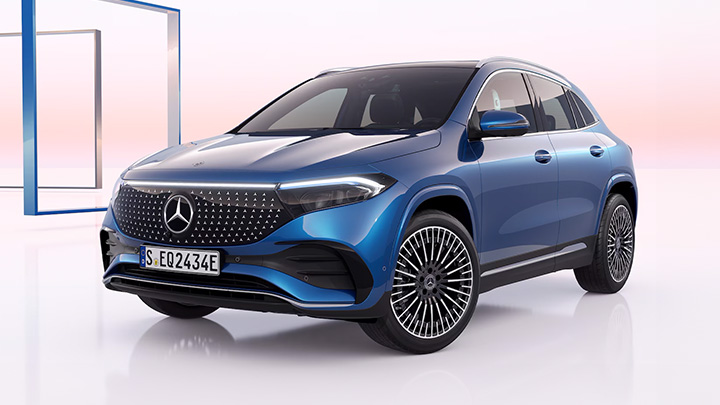 Blue Mercedes-Benz EQA parked in front of a white and pink background